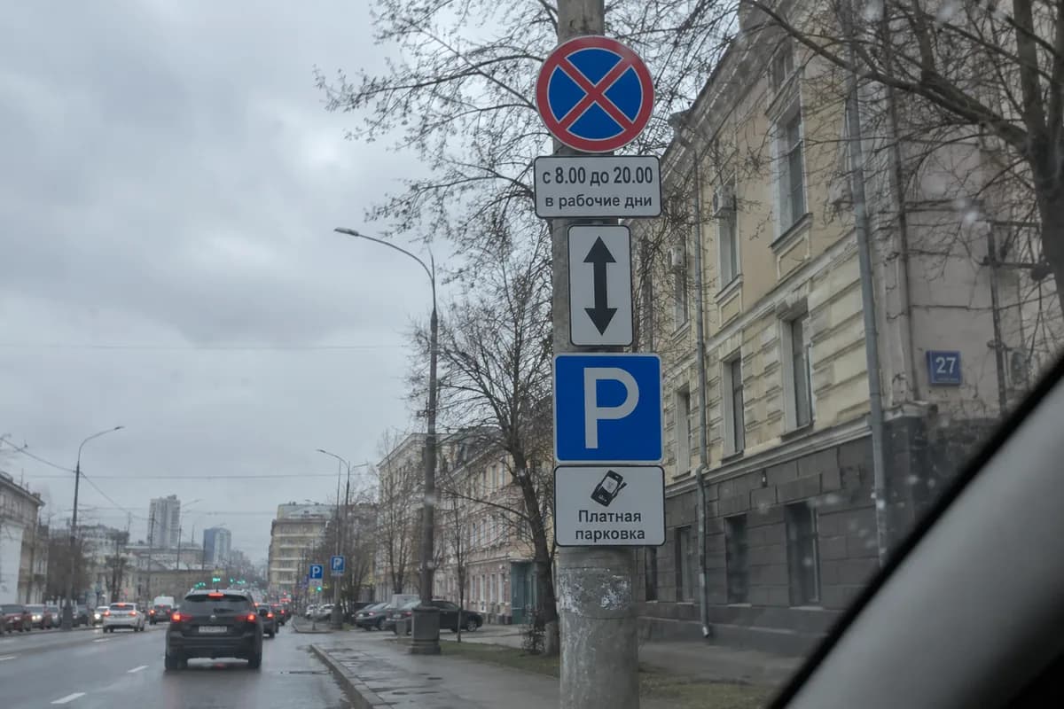 Столб с дорожными знаками: остановка запрещена, время действия, парковка, платная парковка